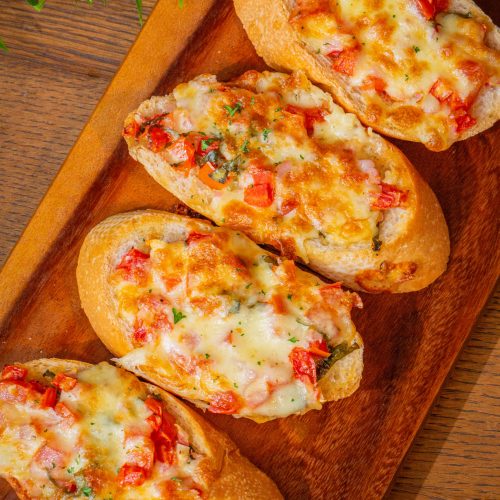 Closeup on italian appetizer bruschettas with tomato sauce and parmesan cheese on the wooden table, horizontal